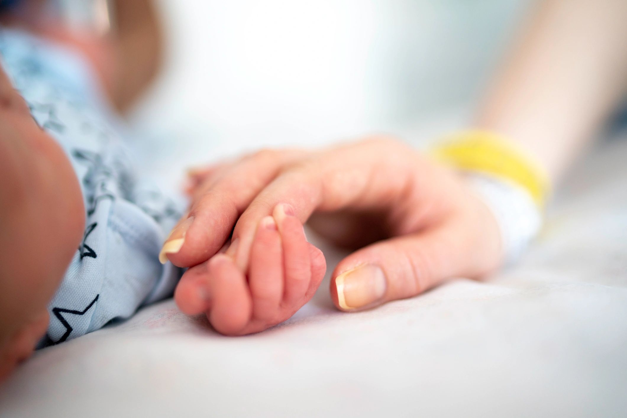 Newborn holding mother's hand