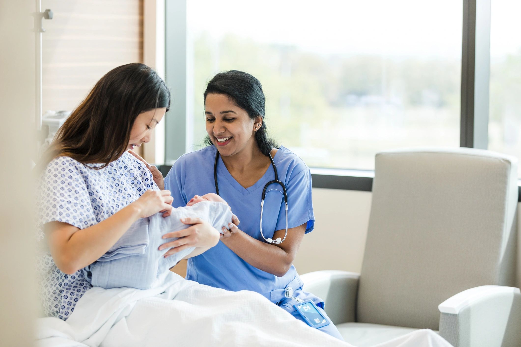Doctor speaking with a new mother at the hospital bedside