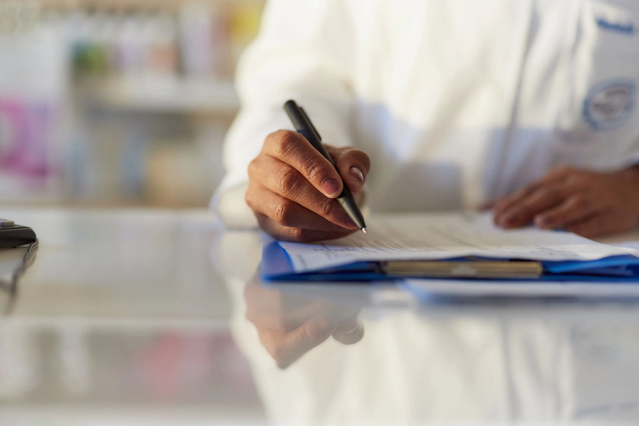 Healthcare professional writing notes and reviewing paperwork